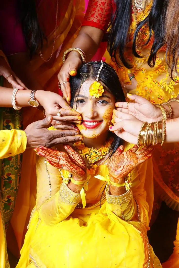 The Art of Drawing Readers In: Your attractive post title goes here A festive Haldi ceremony with joyful women in traditional Indian attire, celebrating with smiles and vibrant colors.